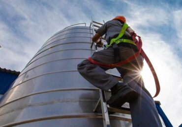 Man climbing fuel tank for cleaning